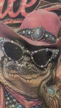 Load and play video in Gallery viewer, A video closeup of the AB crystal rhinestones and graphic print t-shirt showcasing the text "After Awhile" and featuring a crocodile wearing a pink cowboy hat.
